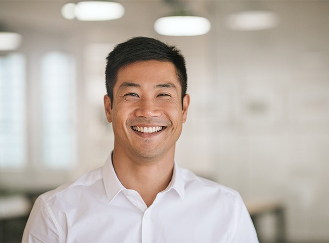 Man in white shirt smiling in office